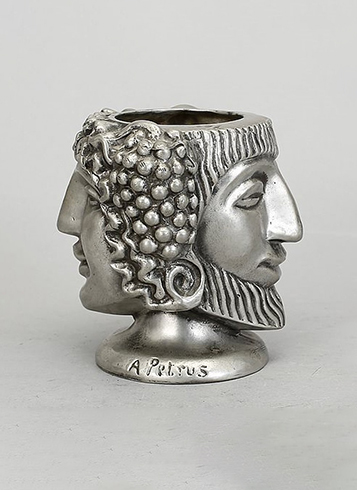 A silver vase with a head on it.