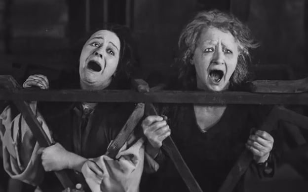 Two women with their mouths open in a black and white photo.