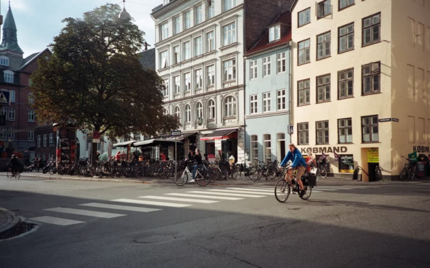 A person riding a bicycle on a street in a city.