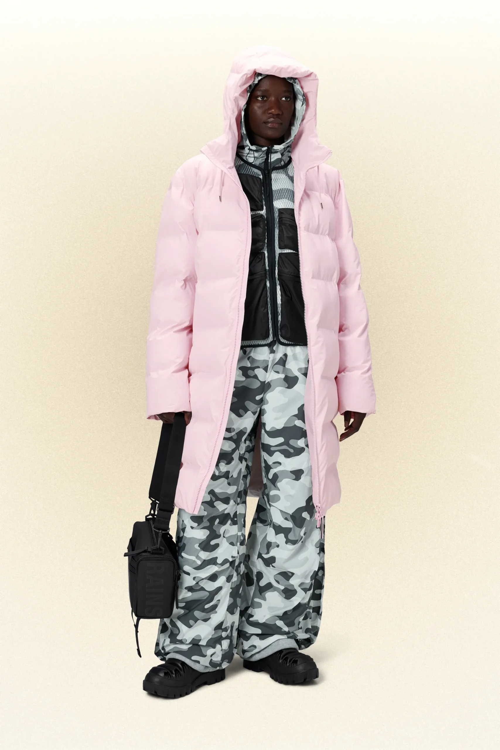 A man in a warm pink puffer jacket and camouflage pants.