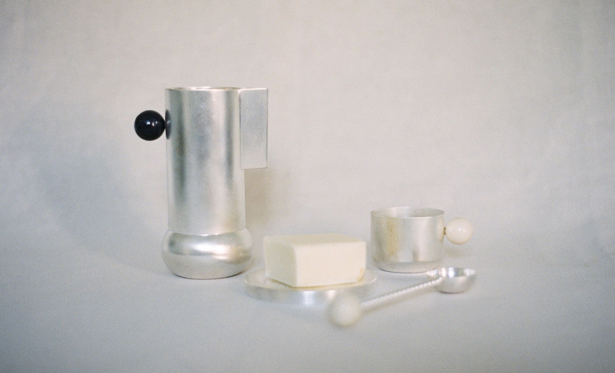 A silver coffee maker and a spoon on a white surface at Copenhagen events.