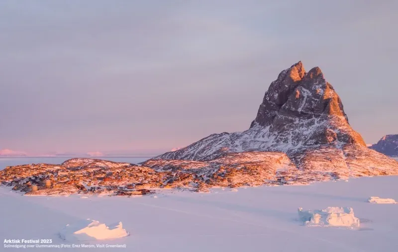 A large rock in the middle of a snowy landscape.