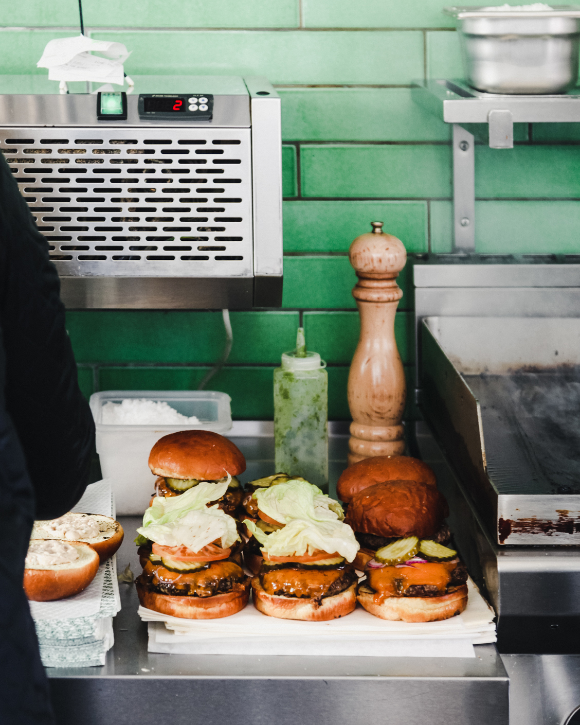 A man is preparing burgers in a Copenhagen restaurant.