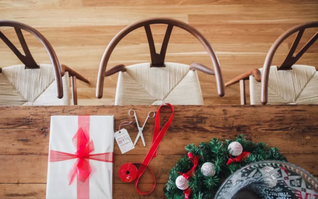 A wooden table with a christmas present on it.