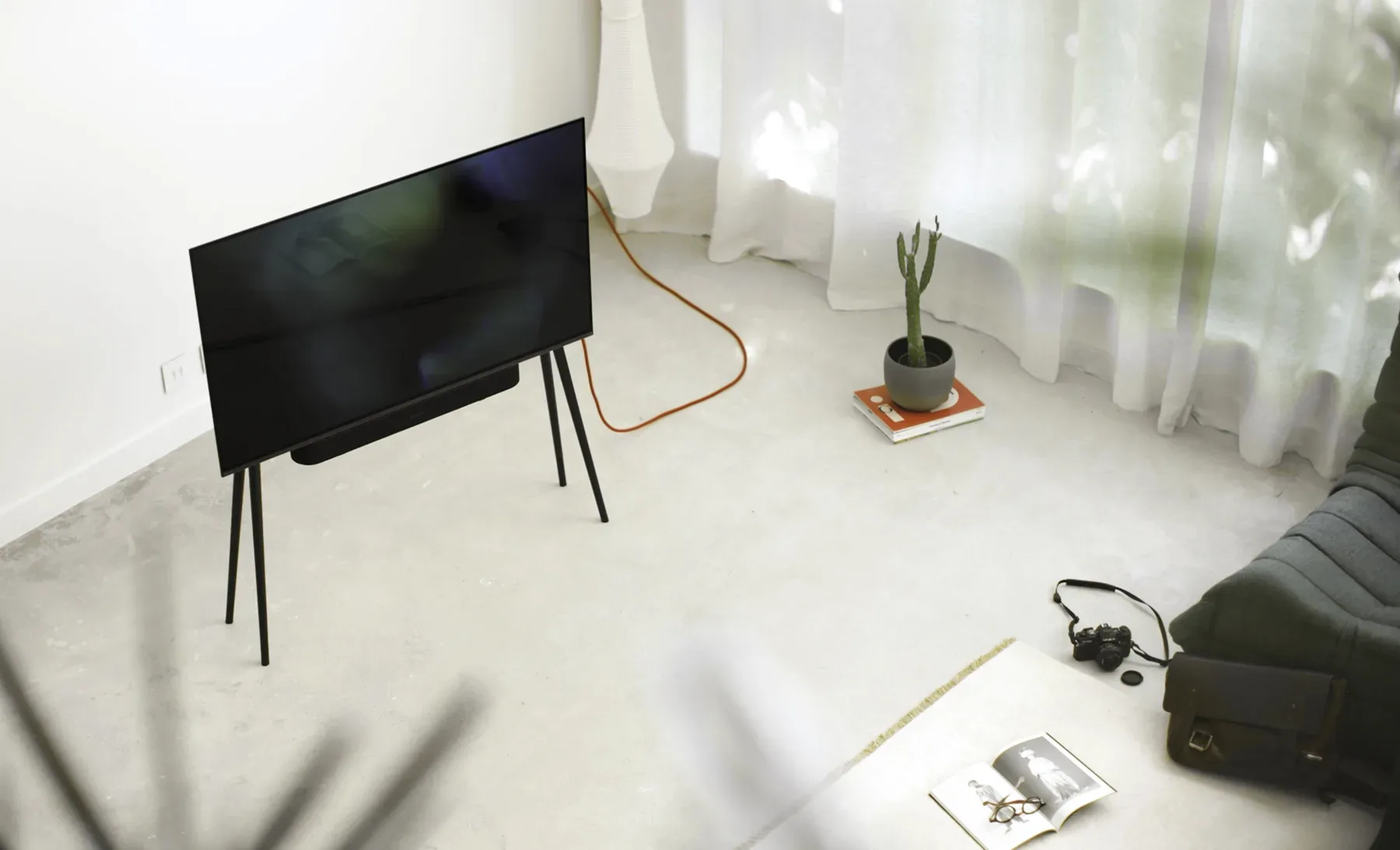 A minimalist living room with a white TV stand.