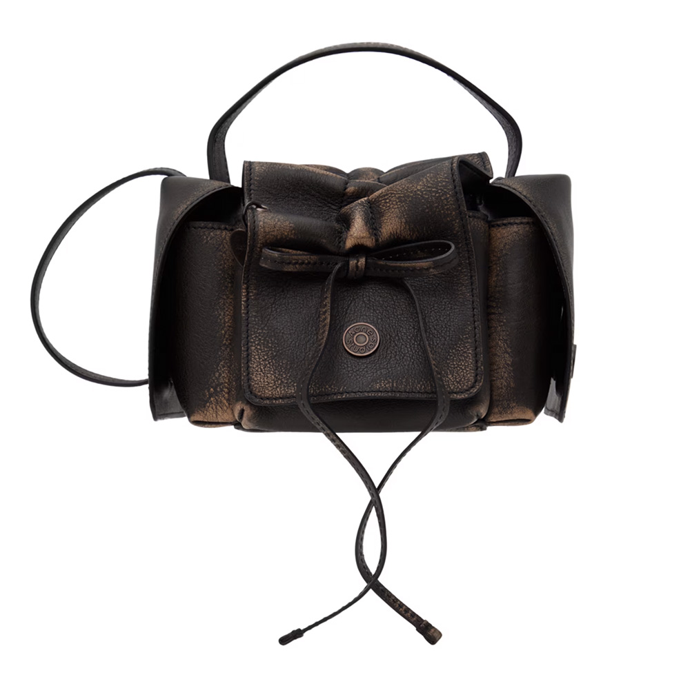 A black leather handbag with a textured finish, featuring a bow on the front and a flap closure, sitting against a plain white background.