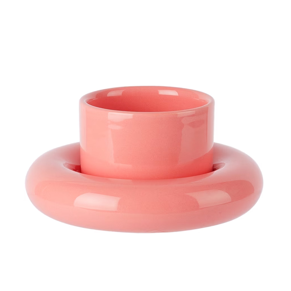 A glossy, pink ceramic vase with a cylindrical top and a circular base.