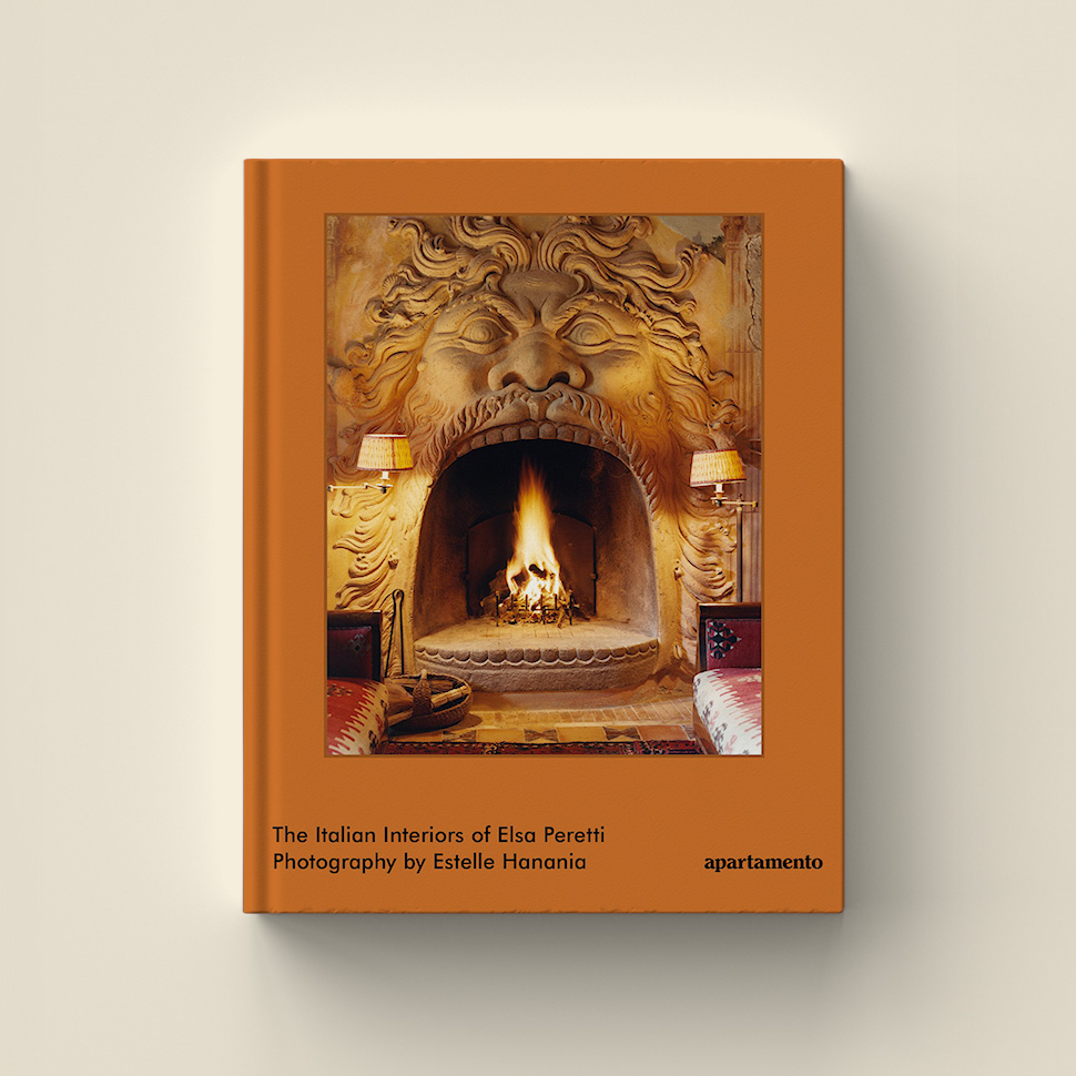 Book cover showing an ornate fireplace framed by a carved stone face. Title reads: 'The Italian Interiors of Elsa Peretti' by Estelle Hanania.
