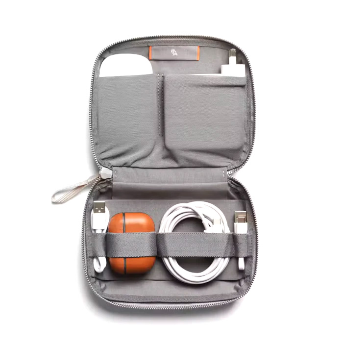 An open gray travel organizer displaying a charger, cable, and an orange power bank secured inside.