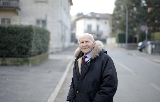 A cheerful older man smiling outdoors