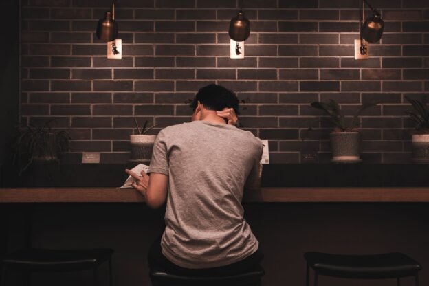 A man relaxing and reading alone in a quiet cafe, a representative image and not a photograph of any person discussed in the article.