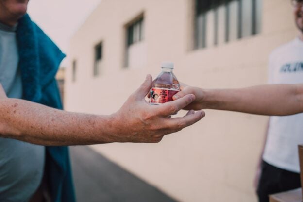 A representative image of two people exchanging a gift outdoors, not a photograph of any person discussed in the article.