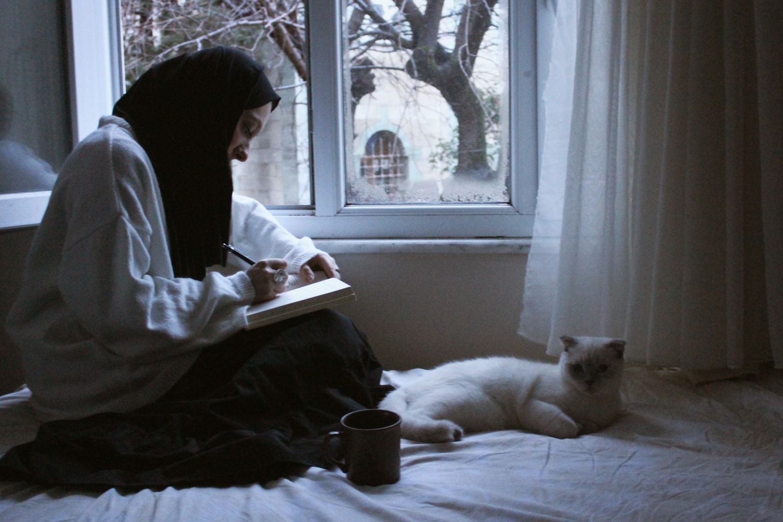 person journaling at window