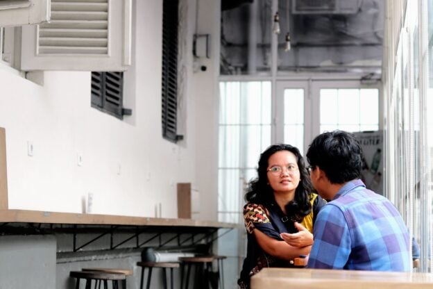 Two people in casual conversation over coffee