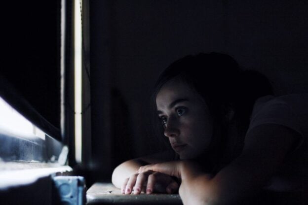 A representative image, not a photograph of any person discussed in the article, showing a woman looking out a window.